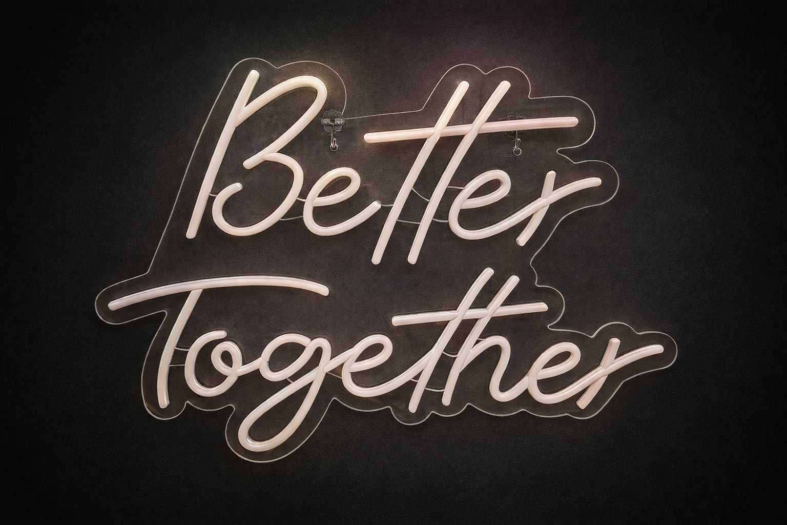 Warm white 65cm Better Together neon light glowing on a dark interior wall.