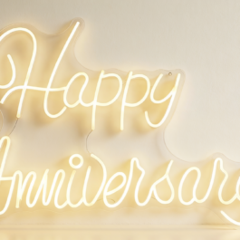 Close up of Happy Anniversary warm white LED light sign mounted on a neutral wall.