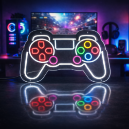Large LED neon gaming controller sign mounted on a wall in a professional RGB gaming room setup with dual monitors and purple lighting.