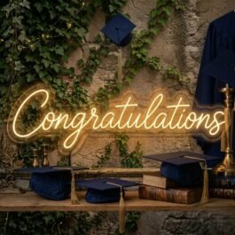 Warm white Congratulations neon sign hanging on a stone wall with ivy and graduation caps.